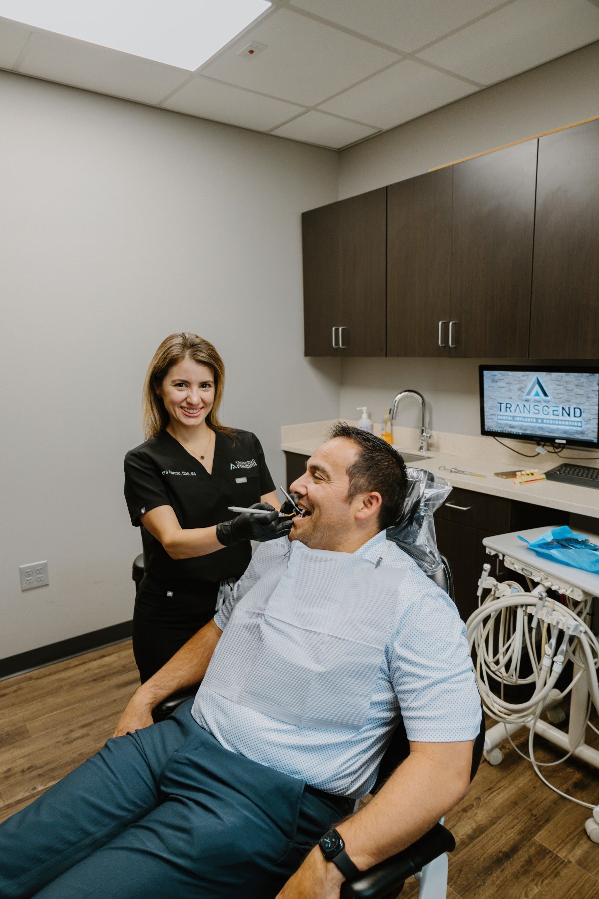 Periodontist and assistant discussing treatment with a patient chairside