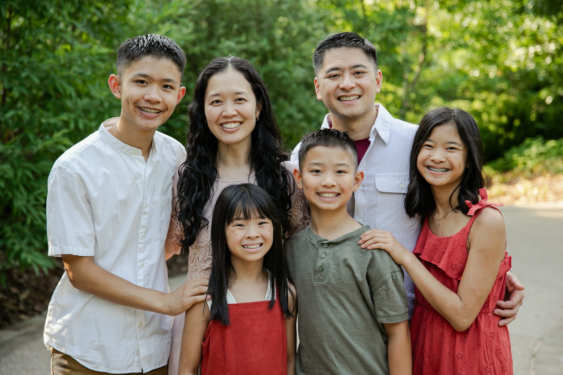 Dr. Tran with his wife and four children outdoors